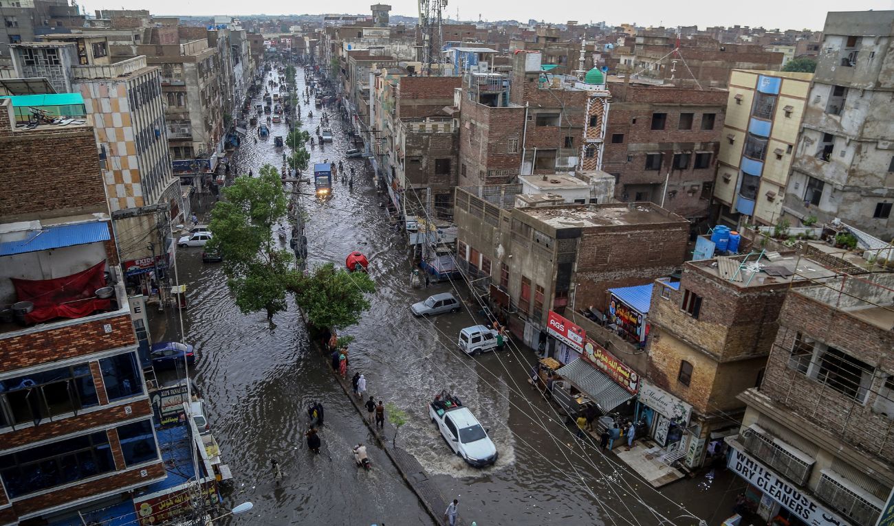 Commuters make their way through a flooded street during heavy monsoon rains in Hyderabad, in Sindh province, on July 14, 2025. (AFP)