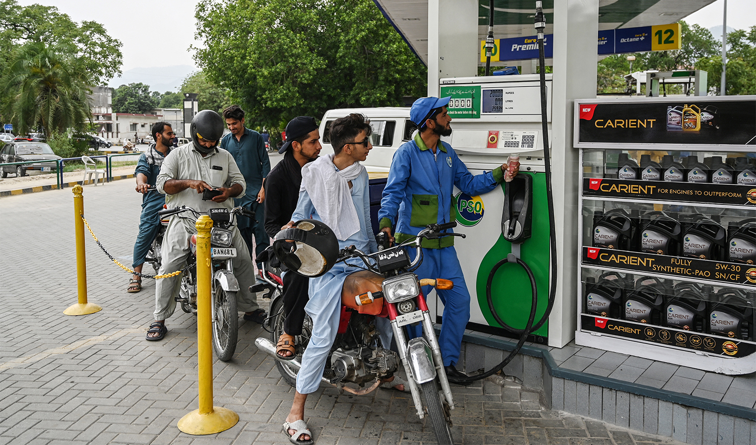 An employee fills the tank of a motorbike at a fuel station in Islamabad on June 16, 2025. (AFP/File)