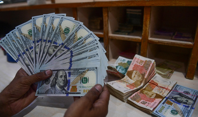 A foreign currency dealer counts US dollars at a shop in Karachi, Pakistan, on May 19, 2022. (AFP/File)
