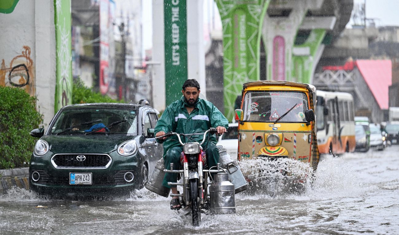 Commuters make their way through a flooded street during heavy monsoon rains in Rawalpindi on July 17, 2025. (AFP/ file)