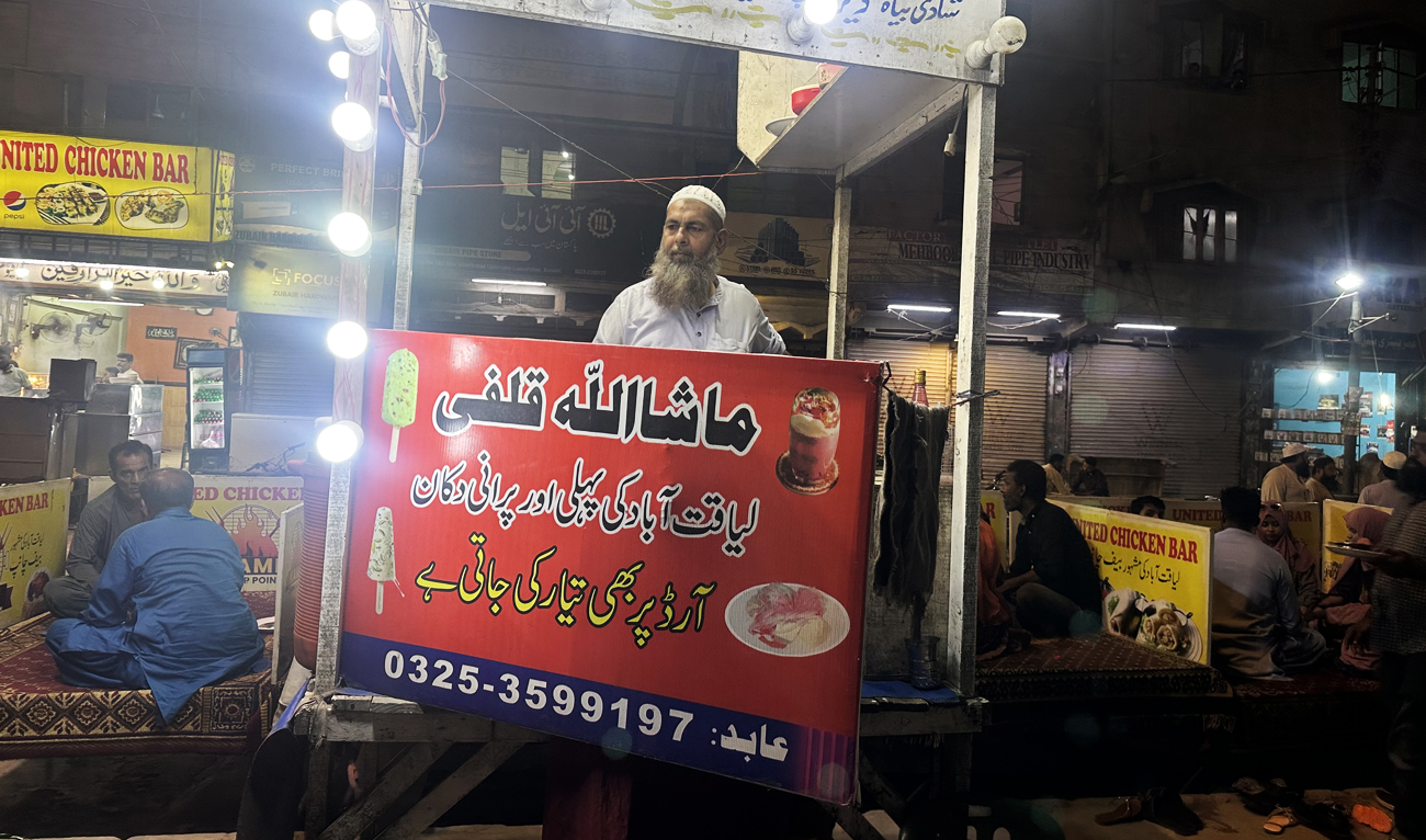 The photograph taken on July 18, 2025, shows Muhammad Abid, a Kulfi vendor, sitting at his small, elevated wooden kiosk in Liaquatabad area of Karachi, Pakistan. (AN)