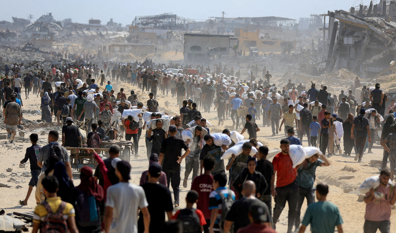 Palestinians gather as they carry aid supplies that entered Gaza through Israel, amid a hunger crisis, in Beit Lahia in the northern Gaza Strip on July 20, 2025. (REUTERS/File)