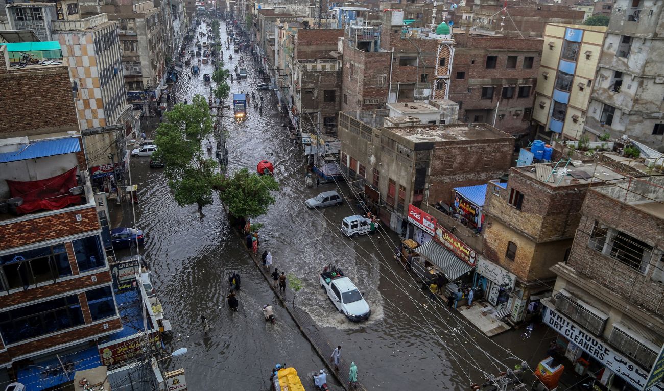 Commuters make their way through a flooded street during heavy monsoon rains in Hyderabad, in Sindh province, on July 14, 2025. (AFP/ file)