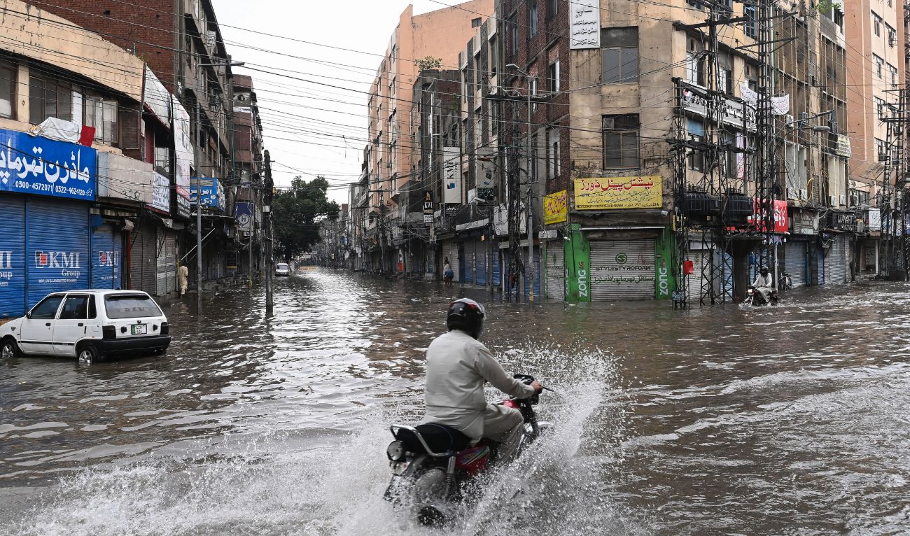 A man rides a motorcycle through a flooded street after heavy rainfall in Lahore on July 23, 2025. (AFP)