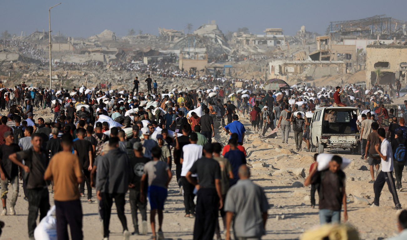 Palestinians carry aid supplies that entered Gaza through Israel, in Beit Lahia in the northern Gaza Strip, on July 30, 2025. (REUTERS)
