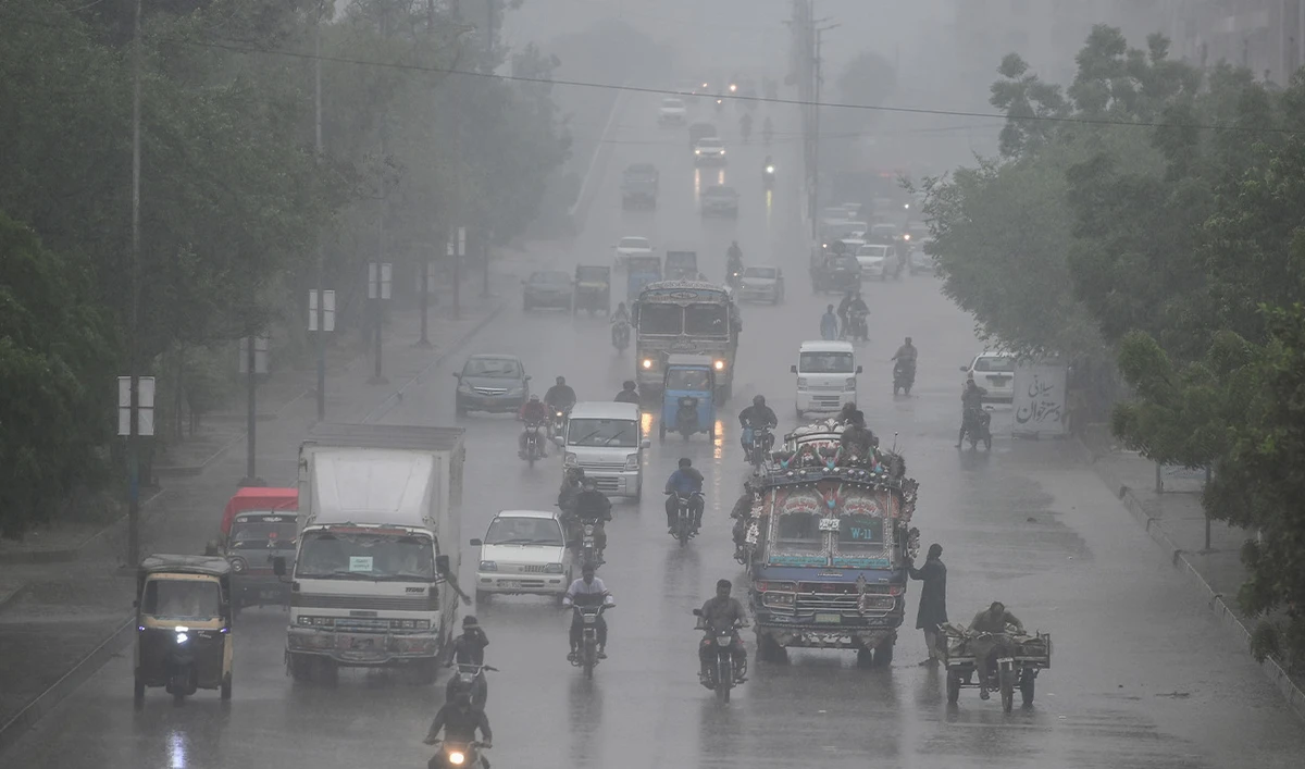 Commuters make their way along a road as it rains in Karachi, Pakistan, on June 28, 2025. (AFP/File)