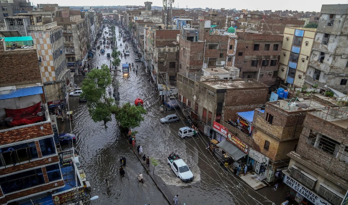 Commuters make their way through a flooded street during heavy monsoon rains in Hyderabad, in Sindh province, on July 14, 2025. (AFP)