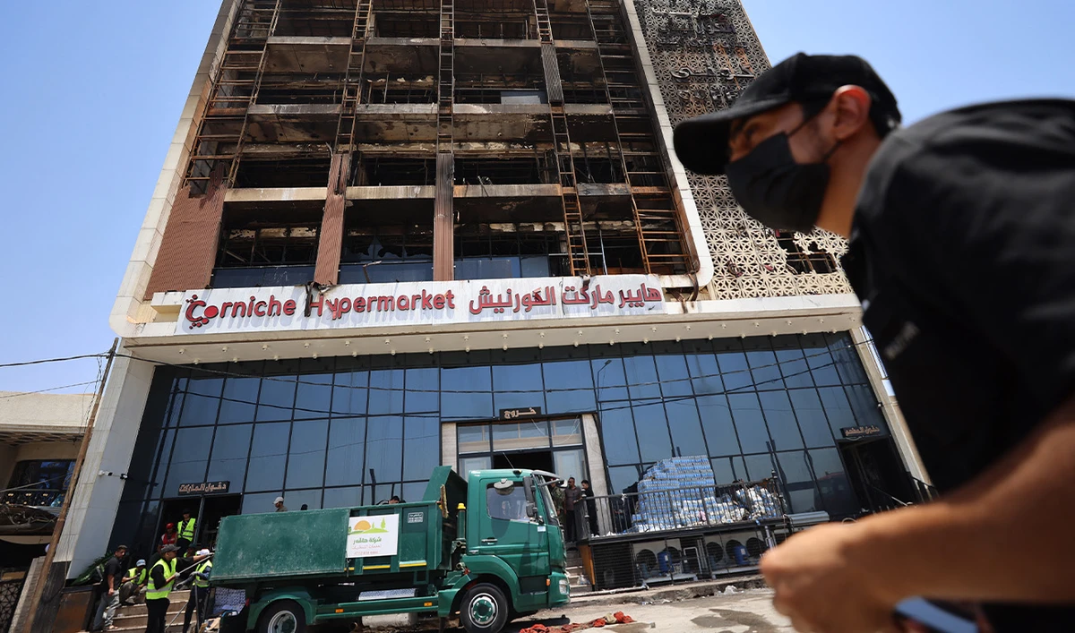 A cleaning operation starts outside the charred building on July 17, 2025, after a fire tore through the newly opened Hyper Mall overnight in the eastern Iraqi city of Kut, killing at least 60 people, according to Iraqi authorities. (AFP)