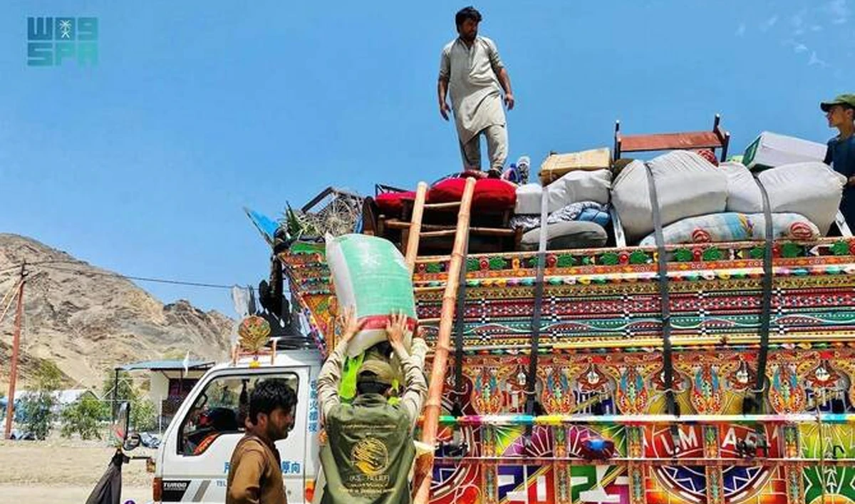 The handout photograph released on July 20, 2025, shows a man unloading a food bag at the Omari camp near the Torkham border crossing in Afghanistan. (SPA)
