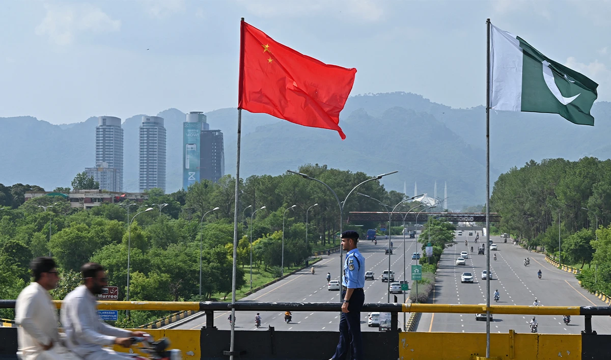 A policeman stands guard under the national flags of China and Pakistan along a road ahead of the visit of Chinese Vice Premier He Lifeng, in Islamabad on July 30, 2023. (AFP/File)