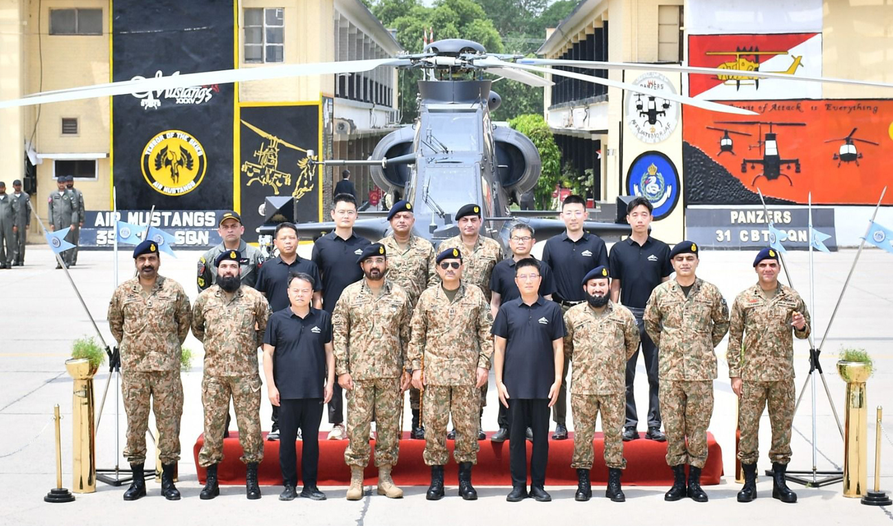 In this handout photo, taken and released by Pakistan’s Inter-Services Public Relations (ISPR) on August 2, 2025, Pakistan Army Chief Field Marshal Asim Munir gestures for a group photograph with officials from China as the military inducts Chinese Z-10ME attack helicopters in defense capability, at the Multan Garrison in Multan. (Handout/ISPR)