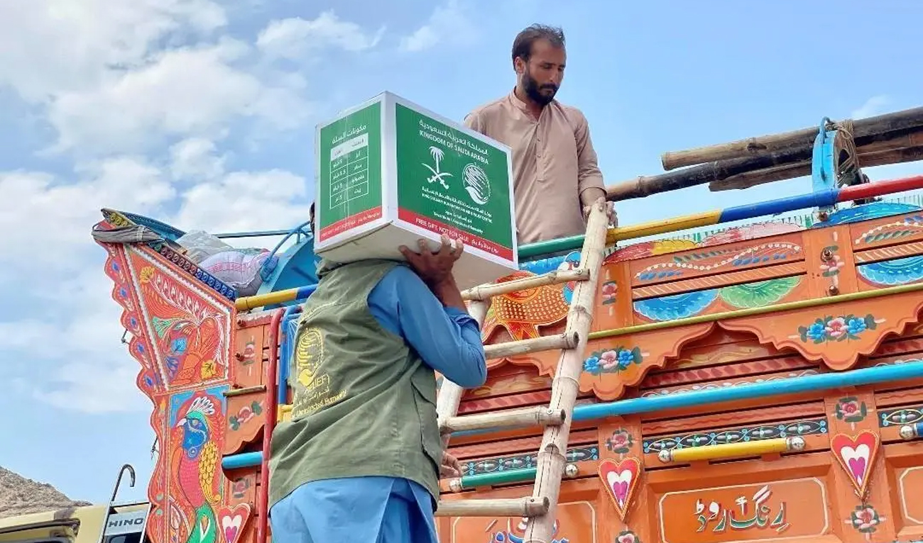 A worker unloads food parcels from a King Salman Humanitarian Aid and Relief Center (KSrelief) truck at Omari Camp near the Torkham border crossing in Nangarhar Province, Afghanistan, on August 2, 2025. (SPA)