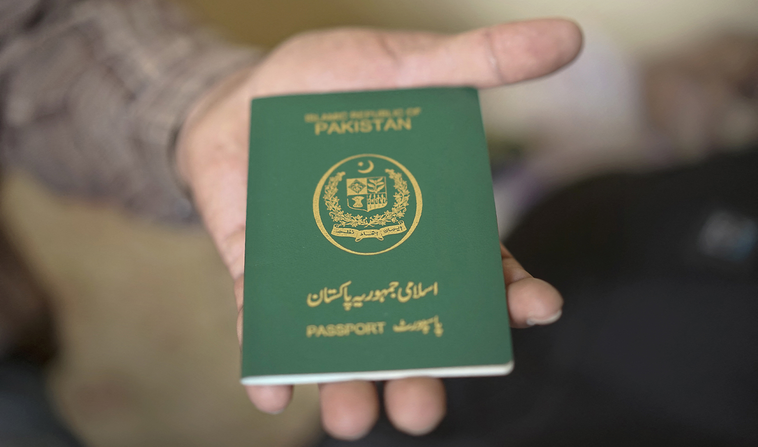 This photo taken on November 3, 2018, shows a man holdong a Pakistani passport in Bangkok, Thailand. (AFP/File)