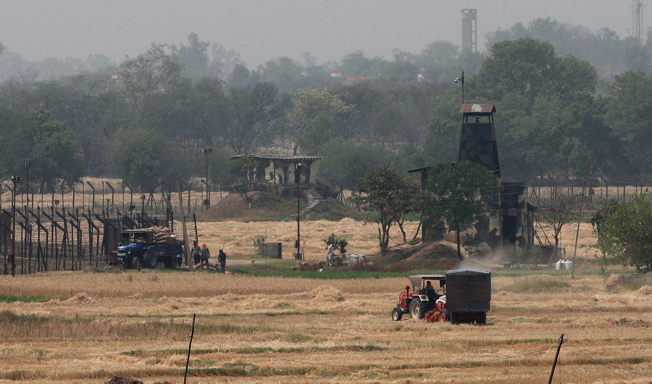 Farmers work in a paddy field near the fenced border between India and Pakistan in Suchetgarh, Jammu and Kashmir on April 30, 2025. (REUTERS/File)