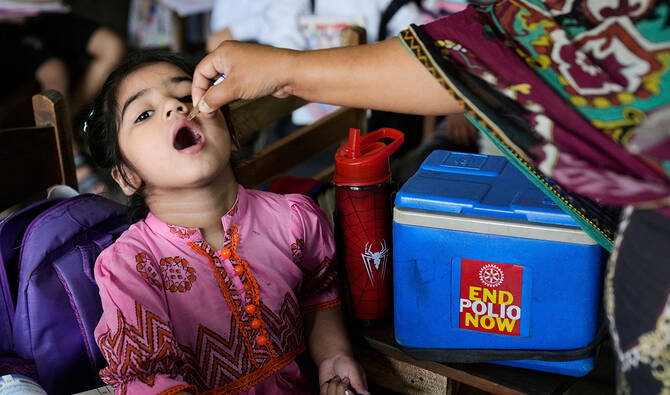 A health worker administers a polio vaccine to a child in a school in Lahore, Pakistan, on April 21, 2025. (AP)