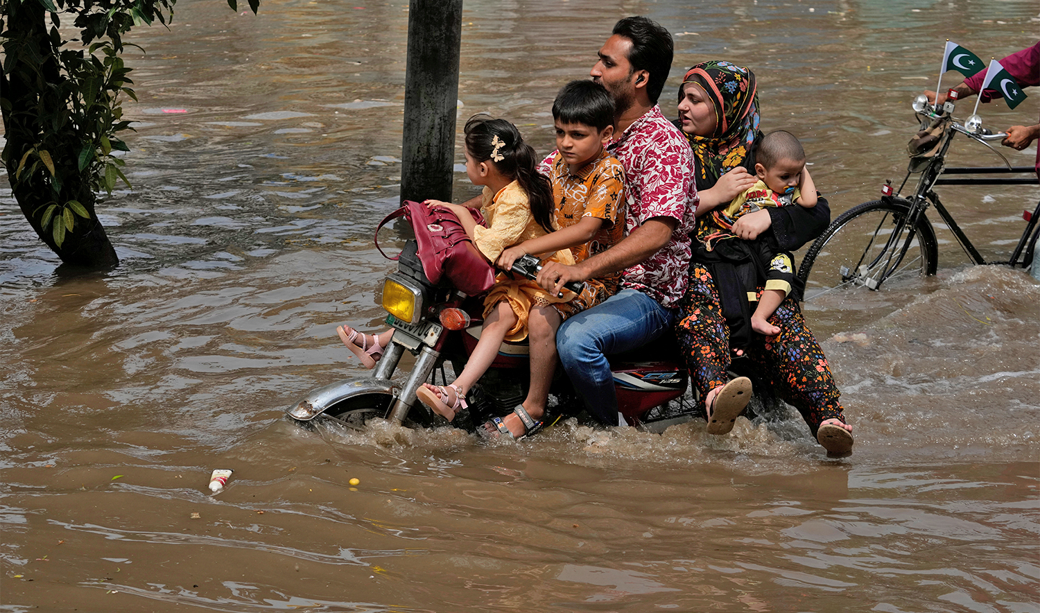 Motorists ride through a flooded road caused by heavy monsoon rain in Lahore, Pakistan, on August 3, 2025. (AP)