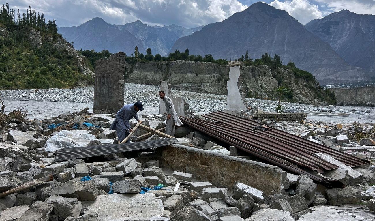 Local residents collect useful items through the rubble of their houses, which were damaged by July 22 floods, at the bank of Hunza River in Sarwarabad, a town in the northern Pakistan on August 6, 2025. (AP/File)