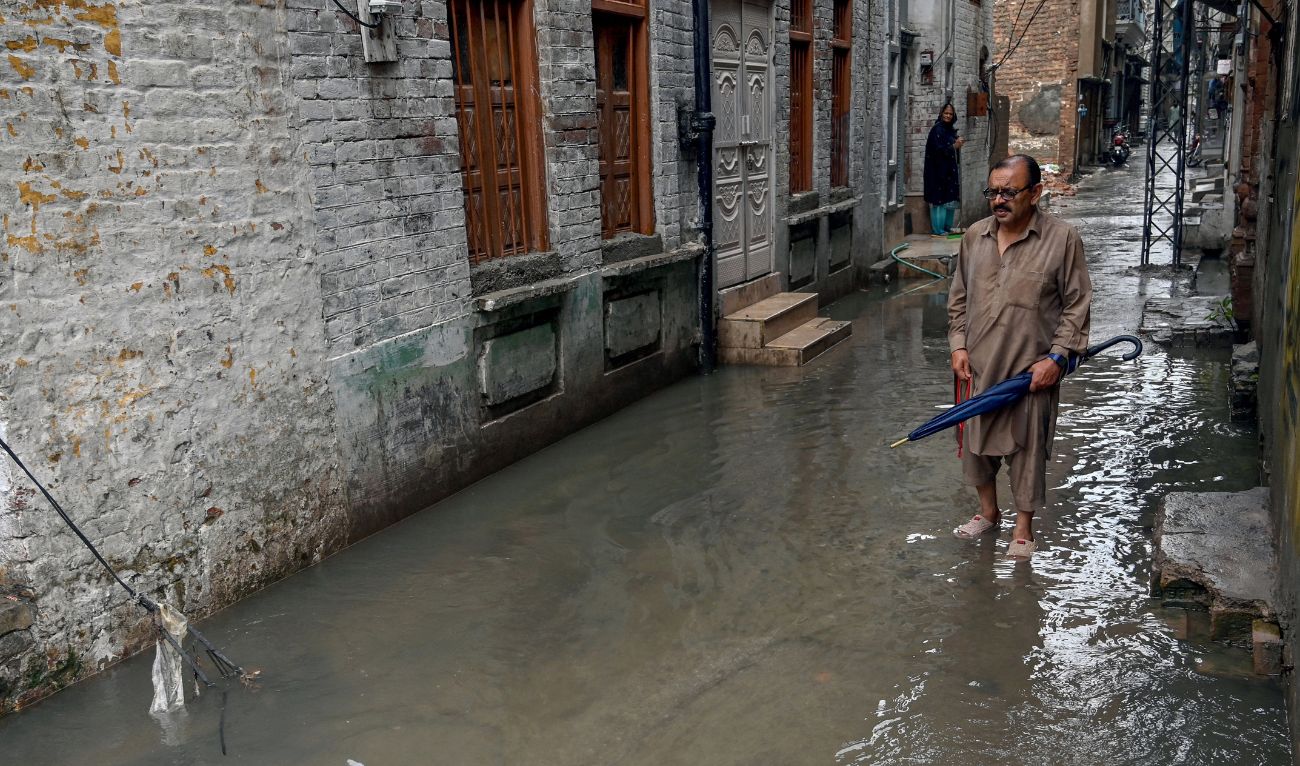 A man wades through a flooded street amidst heavy monsoon rains in Rawalpindi on July 17, 2025. (AFP)