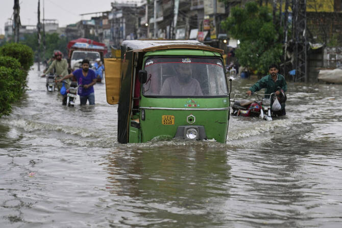 Motorists drive through a flooded road caused by heavy monsoon rain in Lahore, Pakistan, on July 23, 2025. (AP Photo/File)