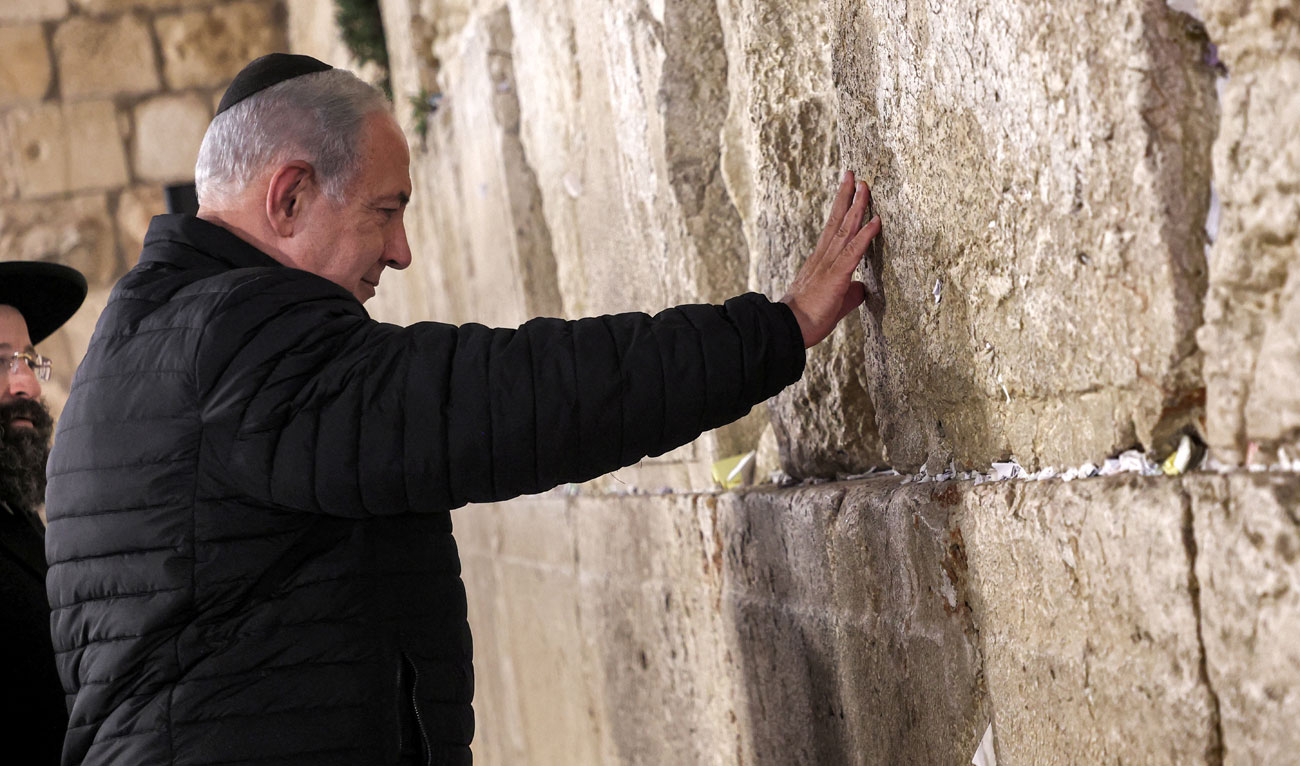 Israel Prime Minister Benjamin Netanyahu prays as he visits the Western Wall, in the old city of Jerusalem on January 1, 2023. (Pool via REUTERS/File)