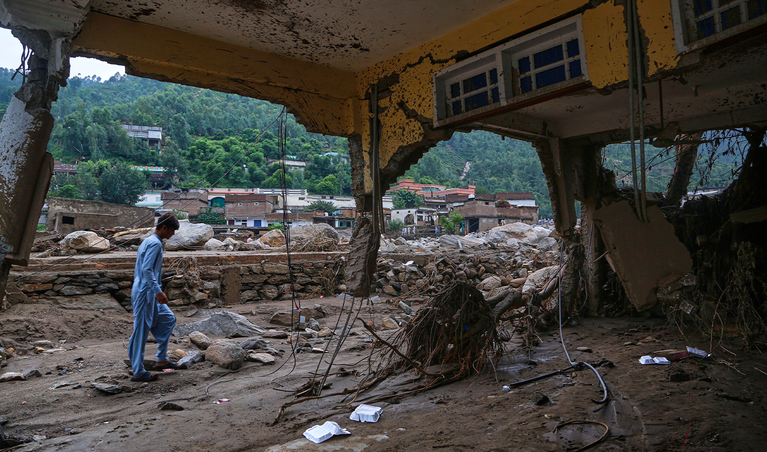 A local resident looks a damaged home following Friday's flash flooding at a neighborhood of Pir Baba, an area of Buner district, in Pakistan's northwest on Aug. 17, 2025. (AP)