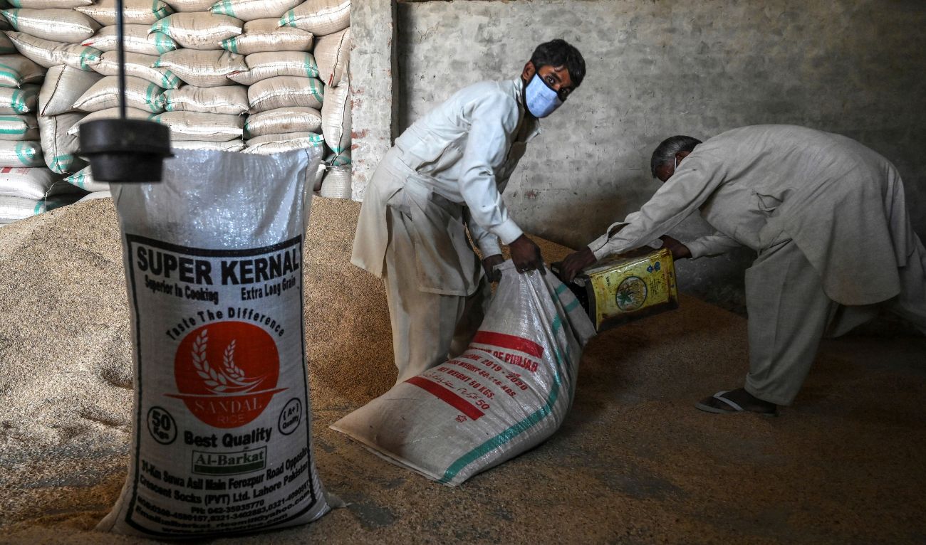 In this picture taken on March 31, 2021 workers fill a sack with rice at the Al-Barkat Rice Mills on the outskirts of Lahore. (AFP/ file)