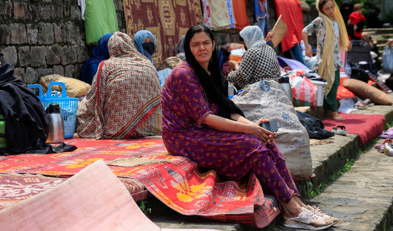 Afghan citizen Tayyaba, 45, who was working in the archive department at RTA - Radio Television Afghanistan, sits with others taking shelter at a public park after they were evicted, as Pakistan has started to deport documented Afghan refugees ahead of its deadline for them to leave, in Islamabad, Pakistan, on August 15, 2025. (REUTERS)