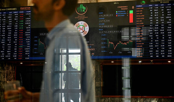 A stockbroker walks past share prices on a financial market board during a trading session at the Pakistan Stock Exchange (PSX) in Karachi on April 9, 2025. (REUTERS/File)