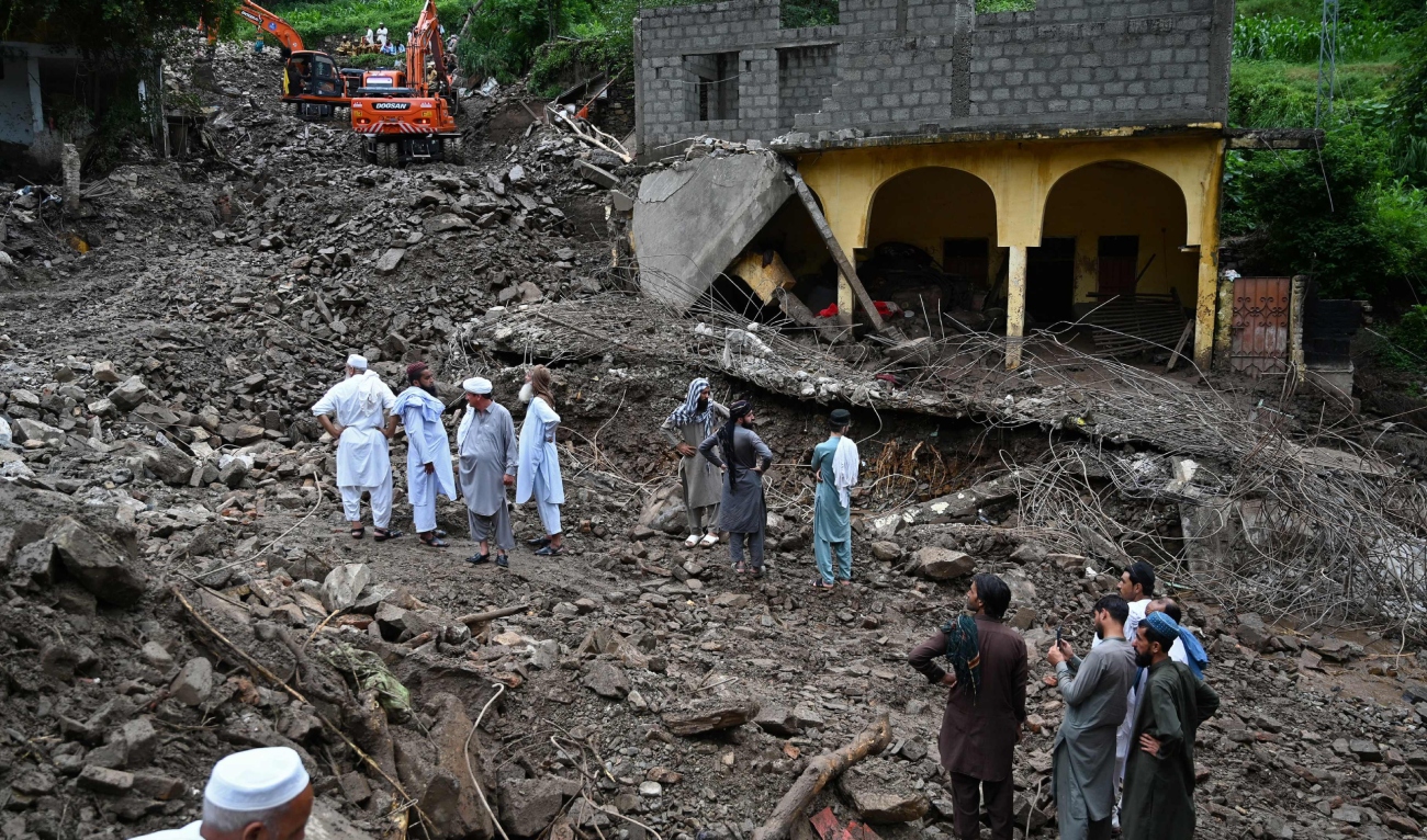 Residents watch as relief personnel search through the rubble of collapsed houses for victims during a rescue operation, a day after a cloudburst at the Dalori village in Swabi district, in Pakistan's mountainous Khyber Pakhtunkhwa province on August 19, 2025. (AFP)
