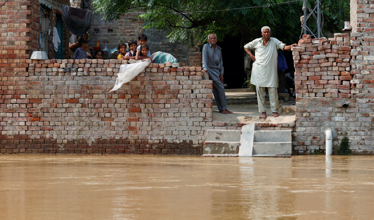 Residents stand at their house, amid flood due to the monsoon rains and rising water level of the Sutlej River, in Hakuwala village near the Pakistan-India border in Kasur district of the Punjab province, Pakistan, on August 23, 2025. (REUTERS)