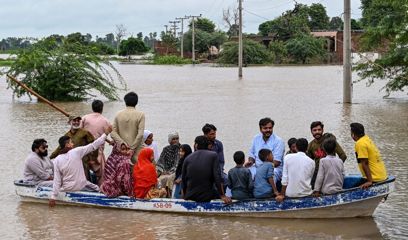 Flood-affected people evacuate on a boat amid rising water levels after heavy rainfall in the Haqu Wala village of Pakistan's Kasur district on August 24, 2025. (AFP)