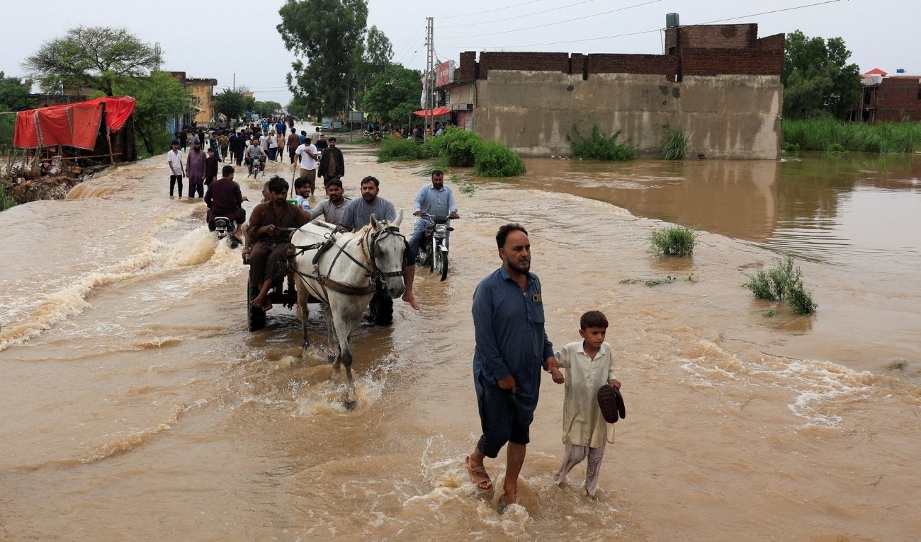 Residents walk along a flooded street following monsoon rains and rising water levels in Sialkot, Punjab province, Pakistan, August 27, 2025. (Reuters)