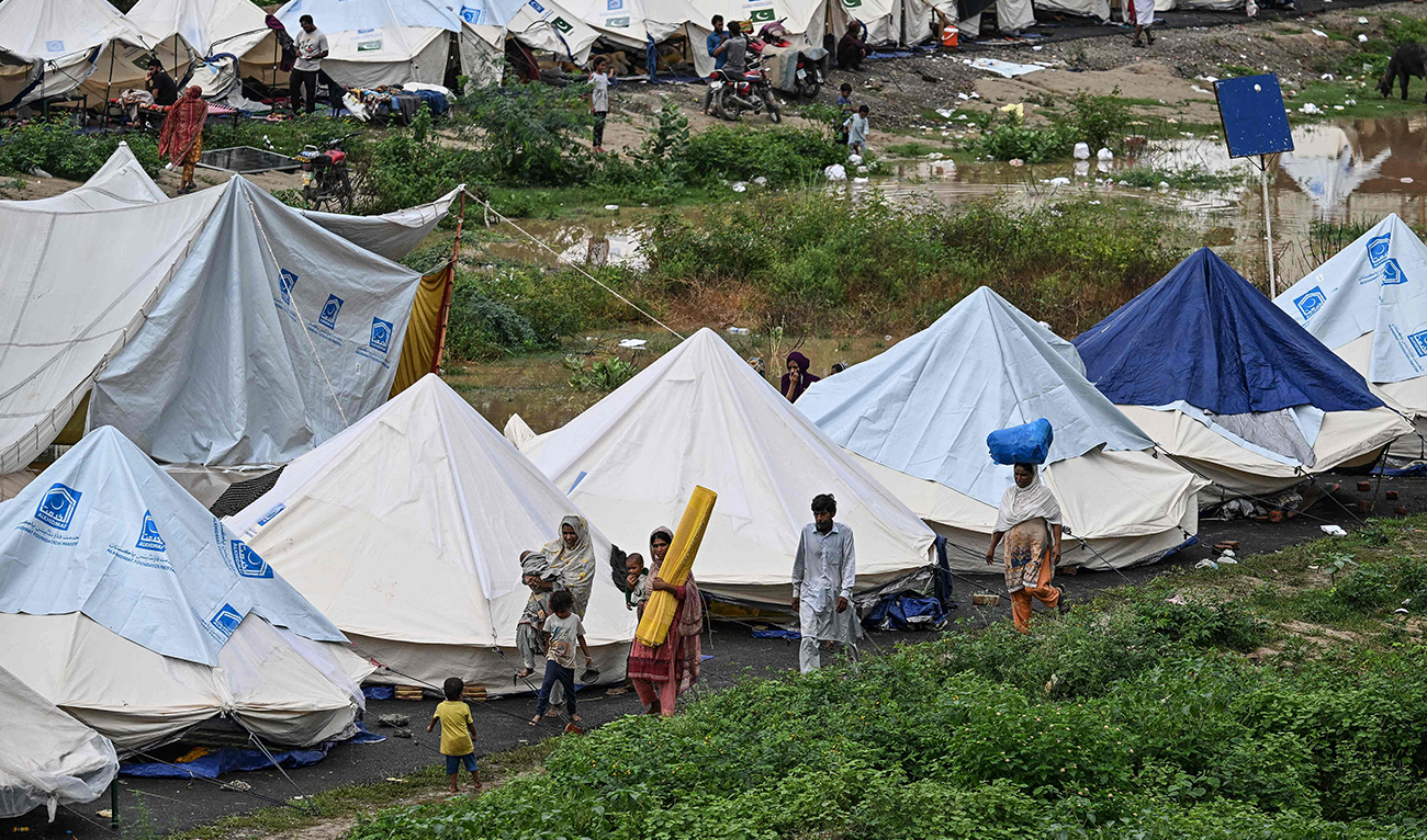 Flood-affected people walk along the shelters at a makeshift camp in Chung, in Pakistan’s Punjab province, on August 31, 2025. Nearly half a million people have been displaced by flooding in eastern Pakistan after days of heavy rain swelled rivers, relief officials said on August 31, as they carried out a massive rescue operation. (AFP)