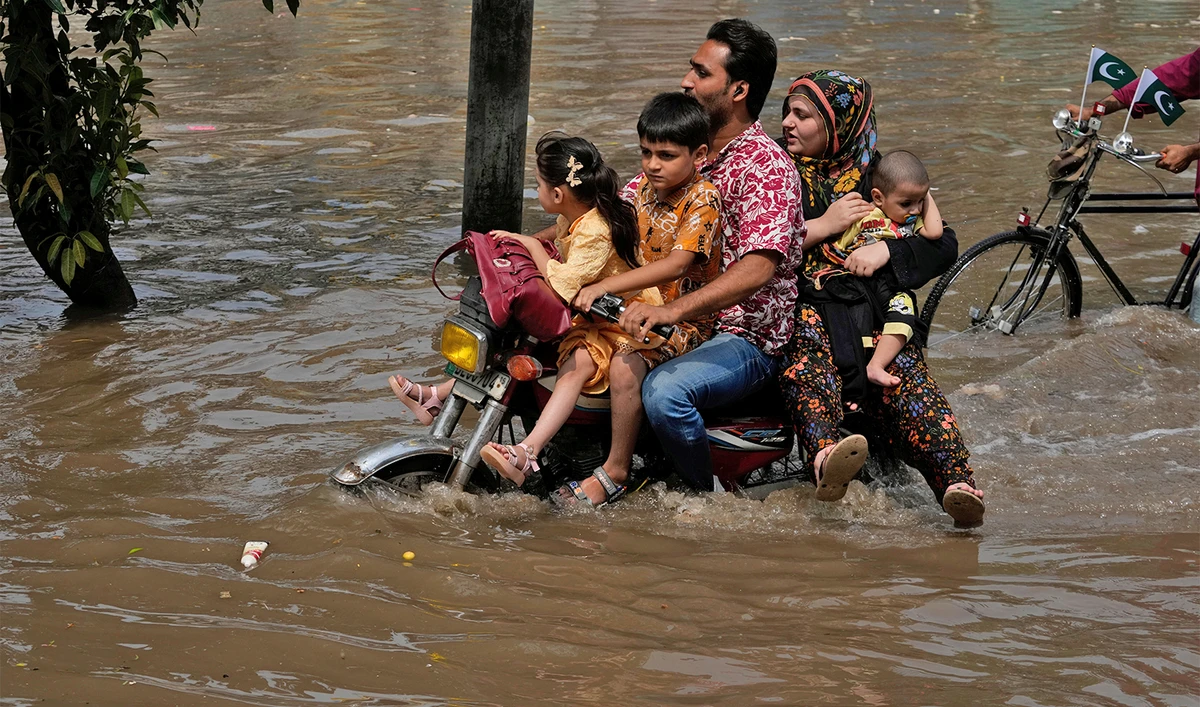 Motorists ride through a flooded road caused by heavy monsoon rain in Lahore, Pakistan, on August 3, 2025. (AP)