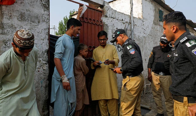 Police officers, along with workers from the National Database and Registration Authority (NADRA), check the identity cards of Afghan citizens during a door-to-door search and verification drive for undocumented Afghan nationals, in an Afghan Camp on the outskirts of Karachi, Pakistan, on November 21, 2023. (REUTERS/File)