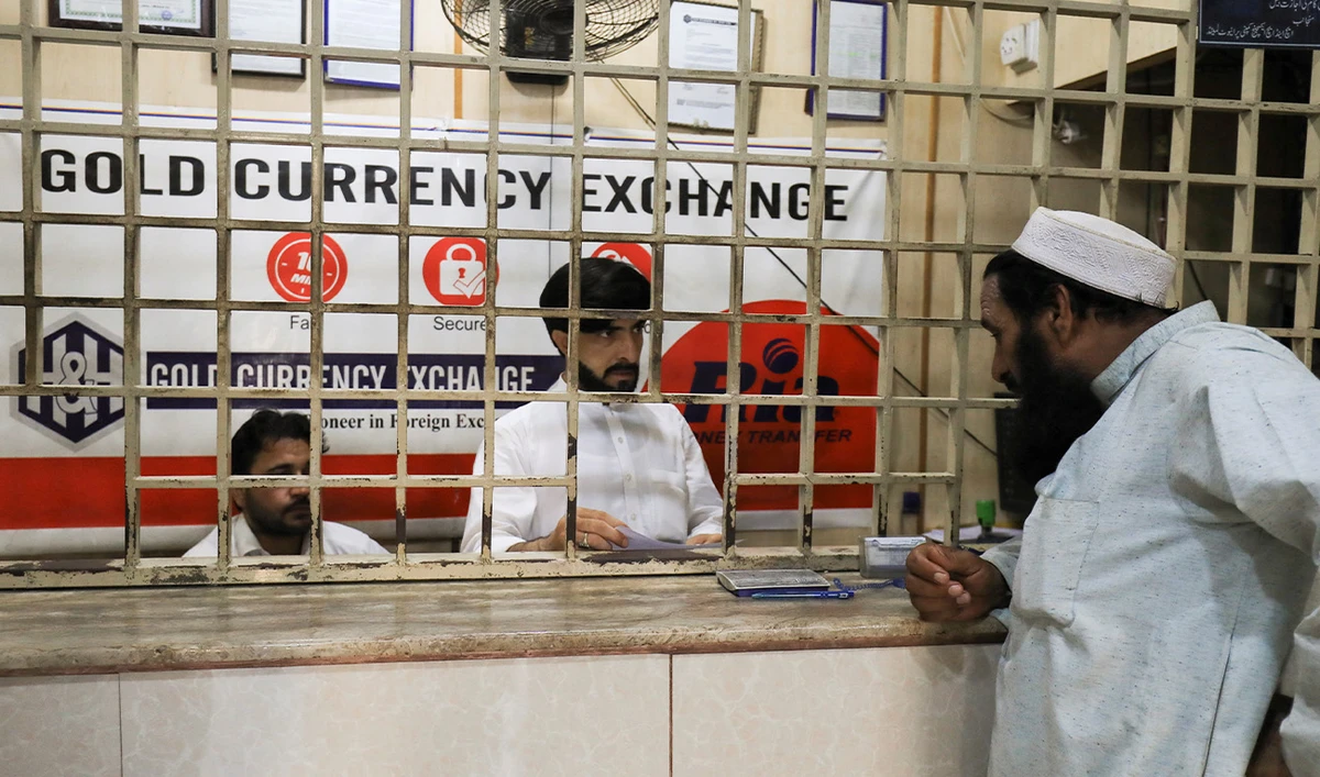 A man speaks with a currency dealer, at a foreign exchange shop, in Peshawar, Pakistan September 8, 2023. (Reuters/File)