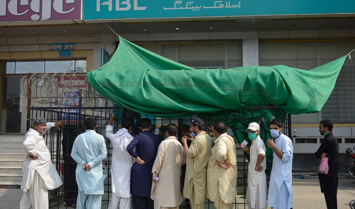 People wait for their turn outside a bank in Islamabad on June 23, 2020. (AFP/File)