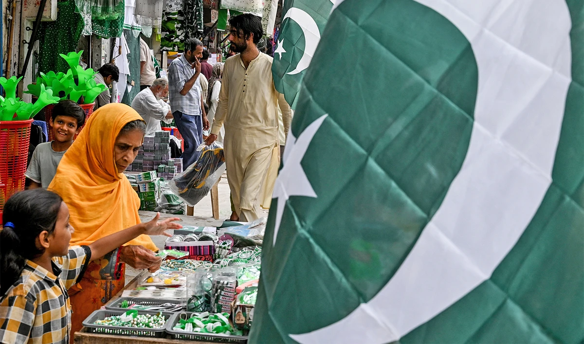Pakistan's national flag is displayed as people buy decorative items at a market ahead of country's Independence Day celebrations, in Lahore on August 10, 2025. (AFP/File)