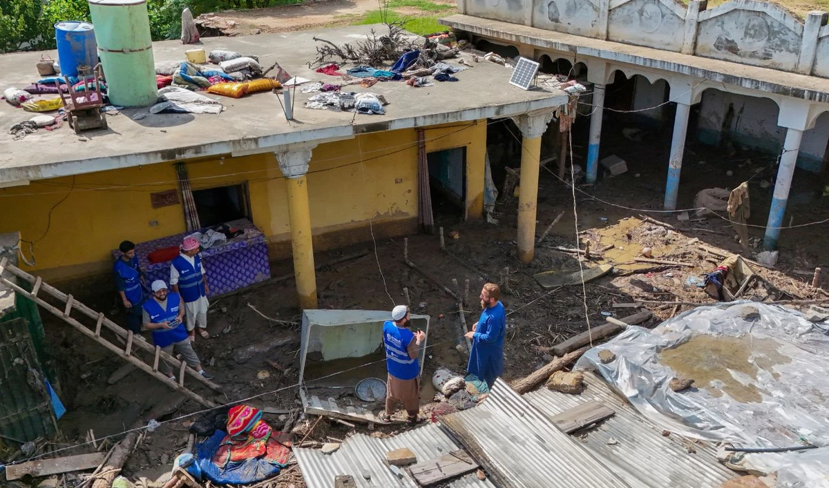 In this aerial picture, volunteers remove debris from a resident's home, after flash floods hit Buner district in northern Pakistan's mountainous Khyber Pakhtunkhwa province on August 18, 2025. (AFP)