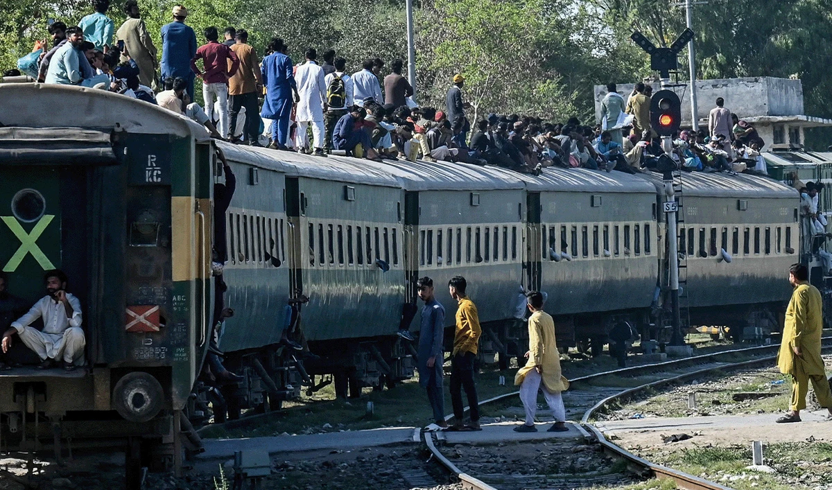 Passengers board a train at a railway station on their way home in preparation for the Eid al-Fitr celebration in Lahore on March 29, 2025. (AFP/File)
