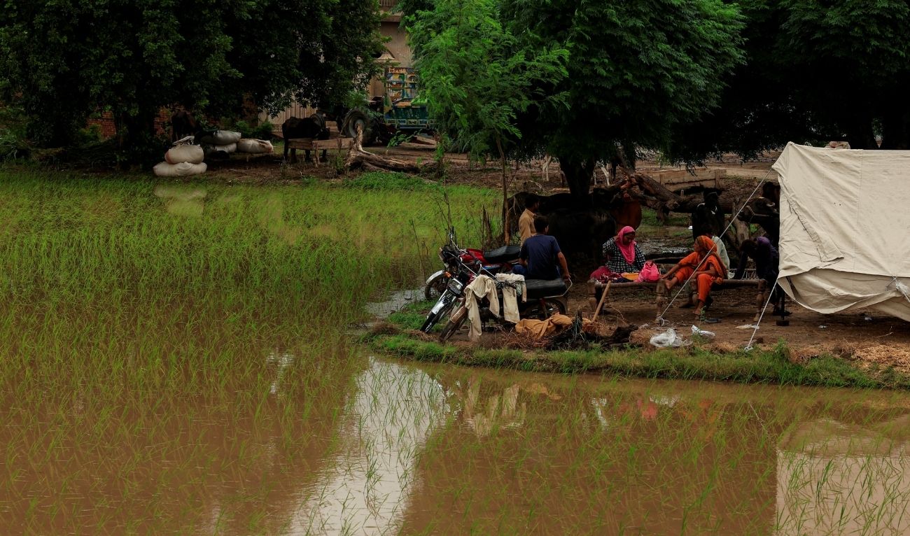 Residents sit outside a makeshift tent beside flooded field, following monsoon rains and rising water levels of the Chenab River, in Patraki village, Chiniot district, Punjab province, Pakistan, August 30, 2025. (Reuters)