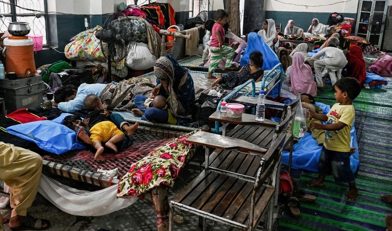 Flood-affected victims rest at a makeshift relief camp inside a school in Lahore on September 1, 2025. (AFP)