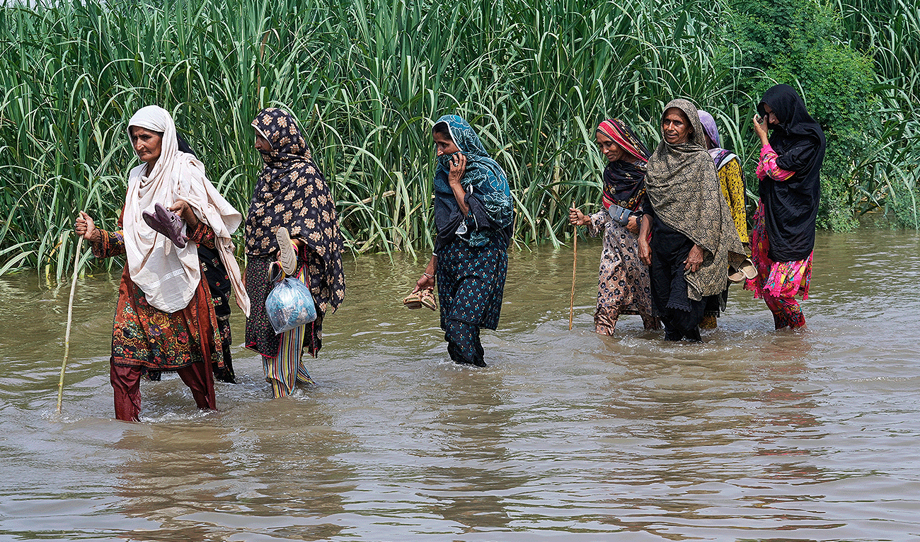 Women wade through a flooded field in Muza Islam Wala, in Jhang district, Pakistan, Tuesday, Sept. 2, 2025. (AP)