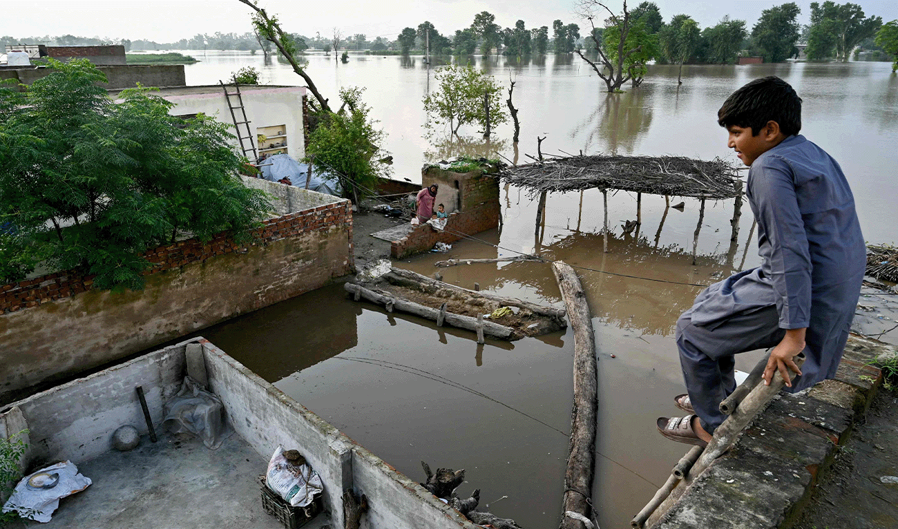 A flood-affected villager looks at the overflowing river Sutlej, as he sits over the rooftop of his house in Kasur district, Punjab province on September 3, 2025. (AFP)