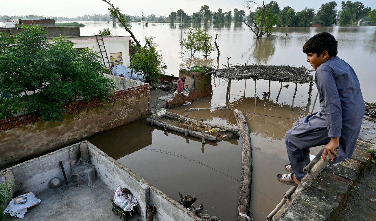 A flood-affected villager looks at the overflowing river Sutlej, as he sits over the rooftop of his house in Kasur district, Punjab province on September 3, 2025. (AFP)