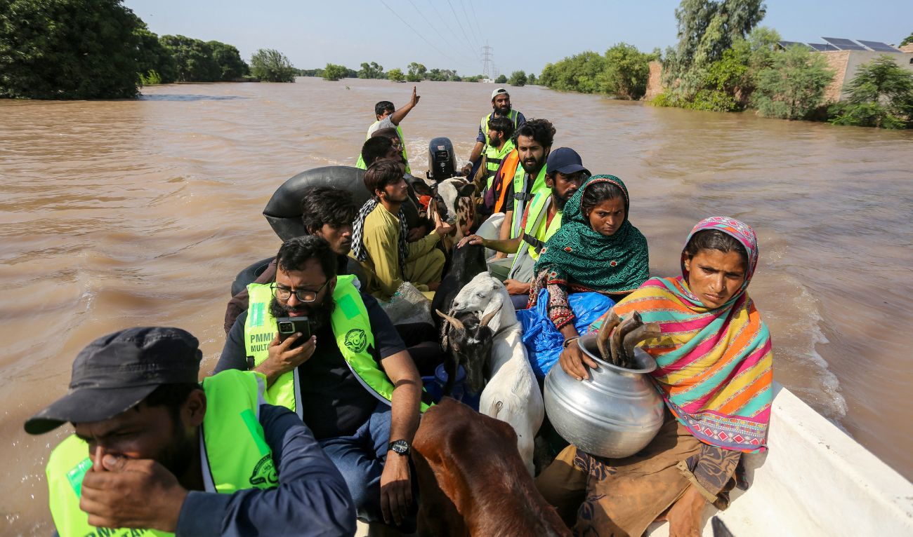 Volunteers rescue flood-affected victims along with their livestock using a boat following heavy rains and overflowing of the Sutlej river, on the outskirts of Multan in Punjab province on September 4, 2025. (AFP)