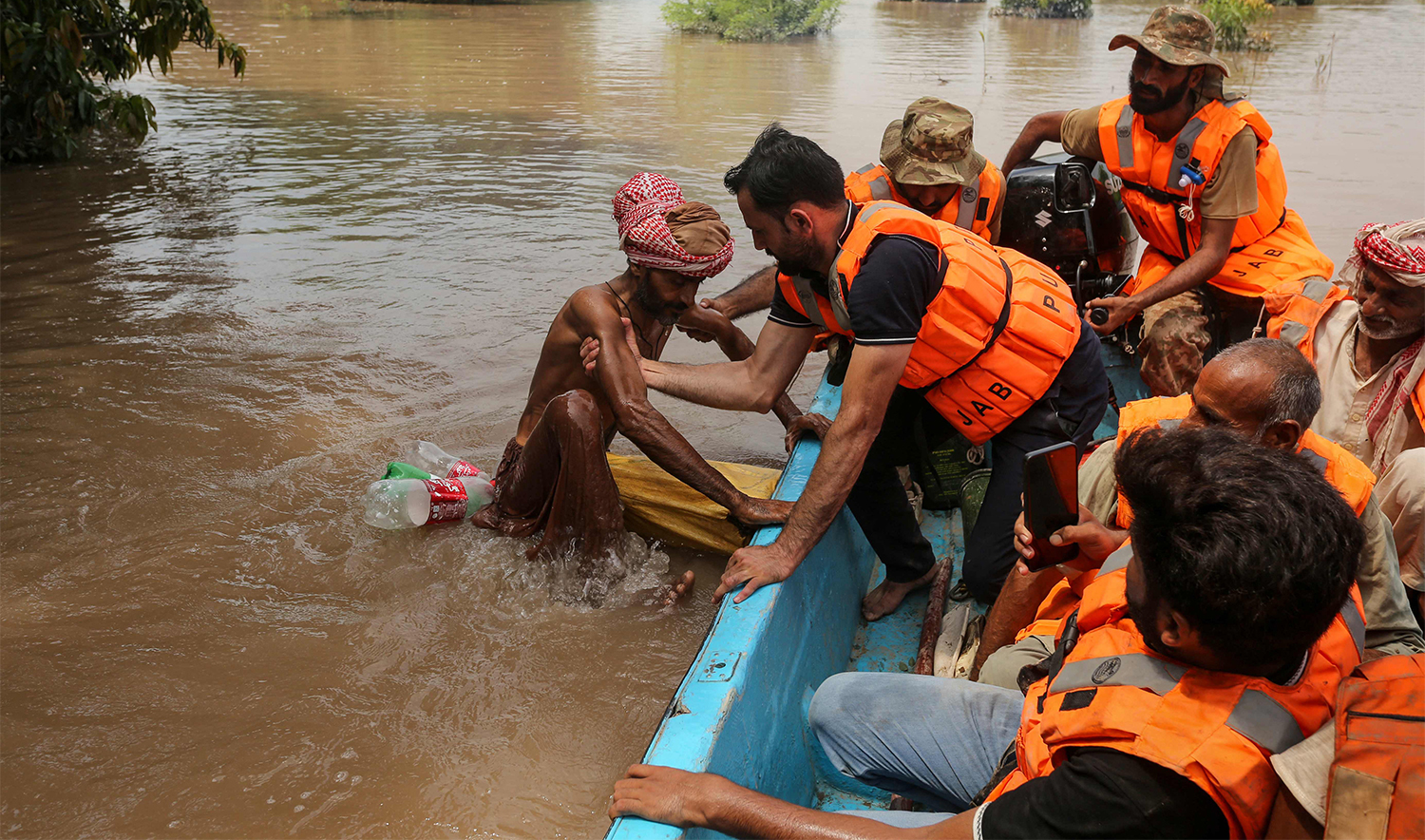 A rescuer pulls a flood-affected man on board a boat after the flood in the Chenab river, in Muzaffargarh in Punjab province on September 6, 2025. (AFP/File)