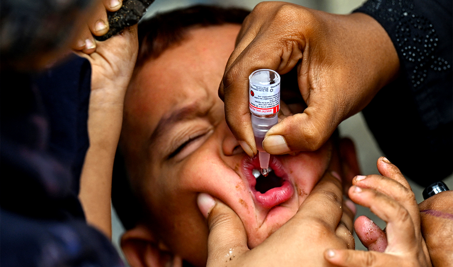 A health worker administers polio drops to a child for vaccination on the first day of a nationwide week-long poliovirus eradication campaign in Karachi on September, 1, 2025. (AFP/File)