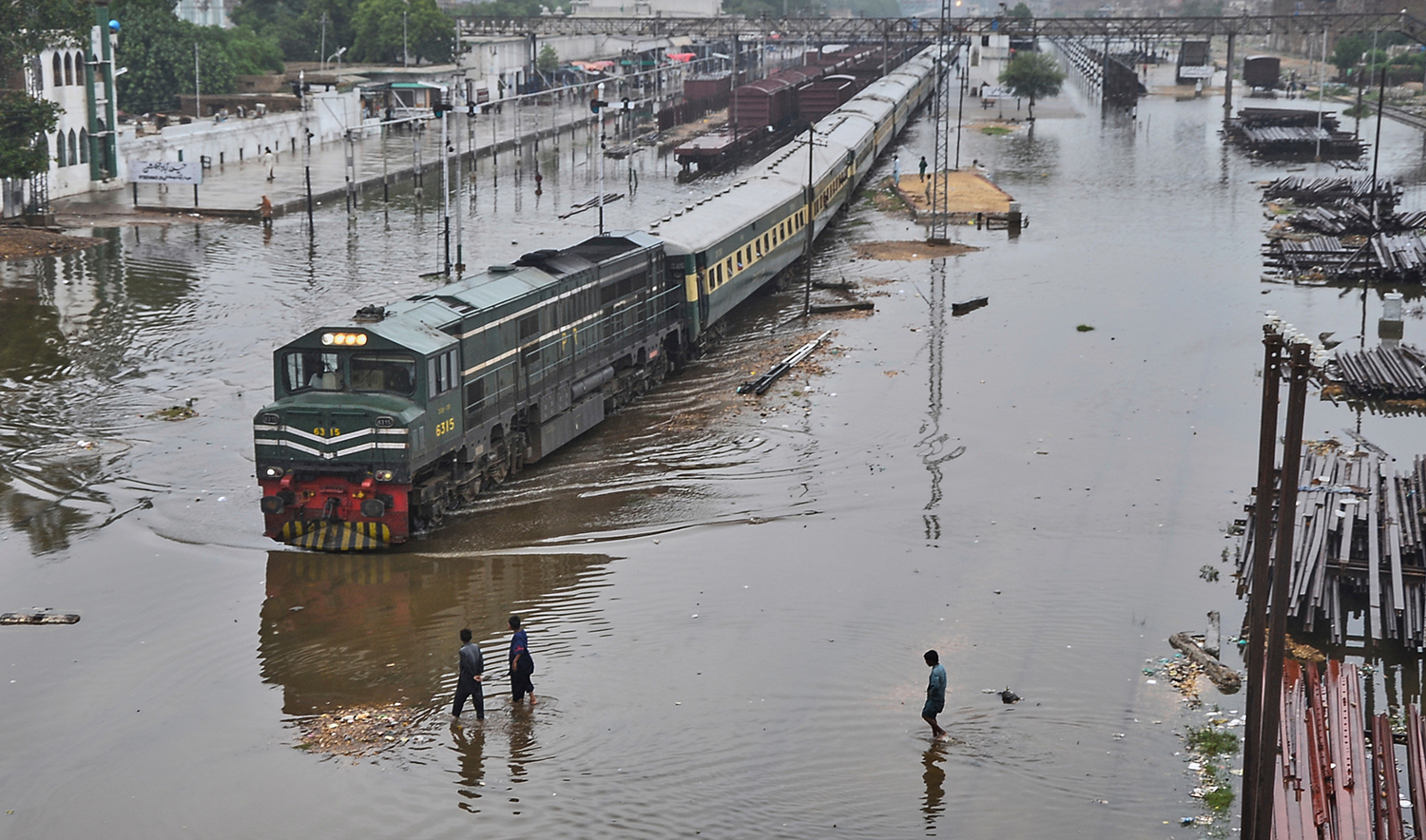 A commuter train leaves a railway station through flooded tracks caused by heavy rains, in Hyderabad, Pakistan, on Sept. 9, 2025. (AP)
