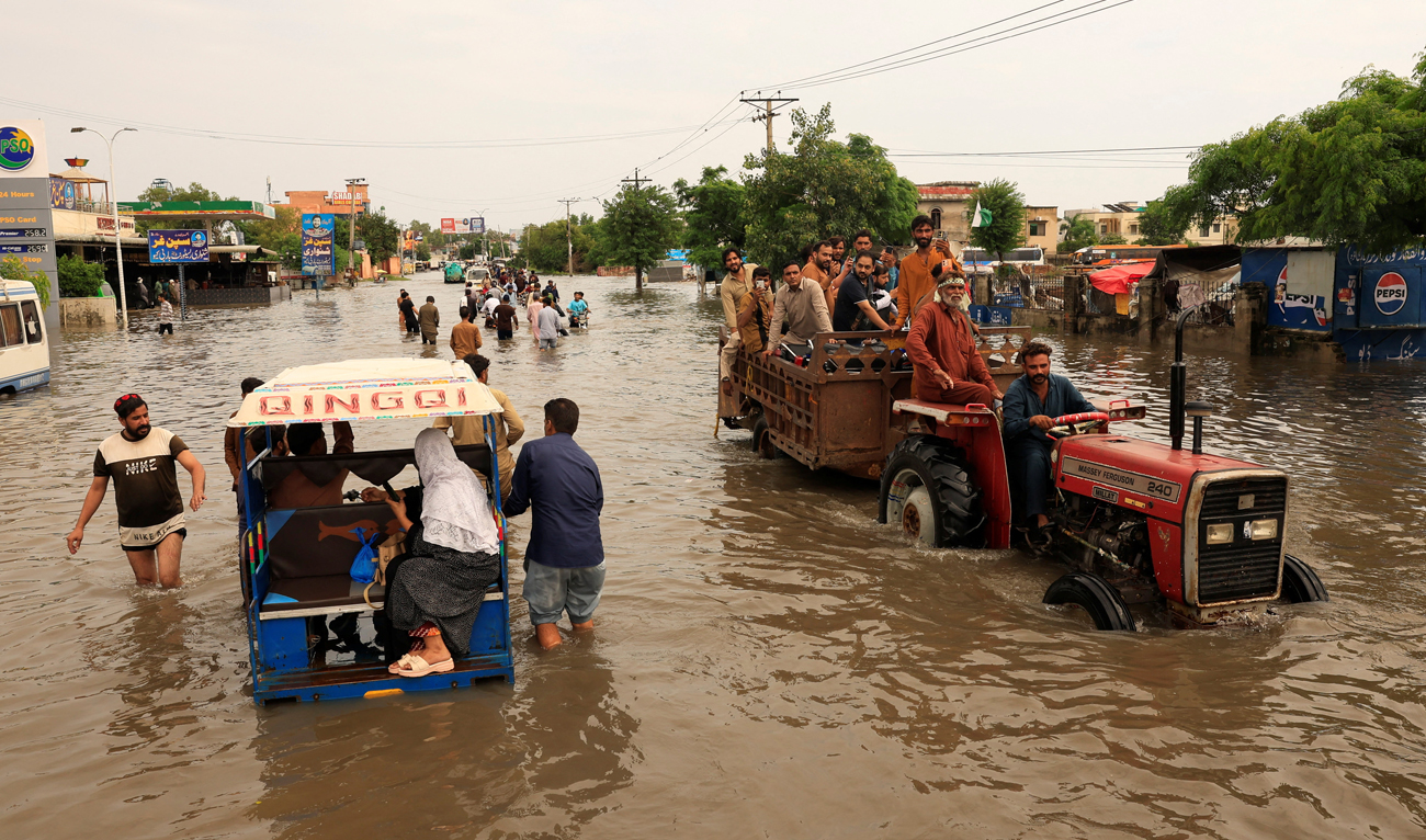 Residents sit on a tractor trolley as they cross a flooded road following monsoon rains and rising water levels in Sialkot, Punjab province, Pakistan on August 27, 2025. (REUTERS)